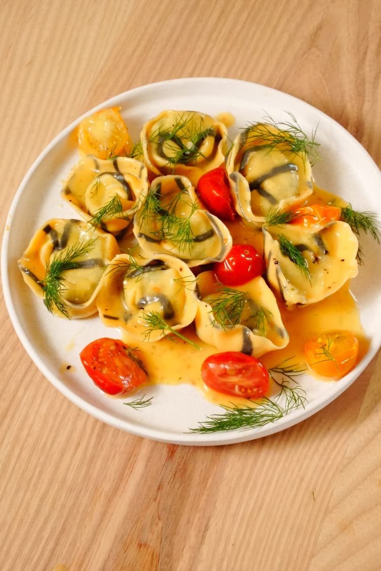 Cappelletti filled with cod, potato & herbs, served with cherry tomato